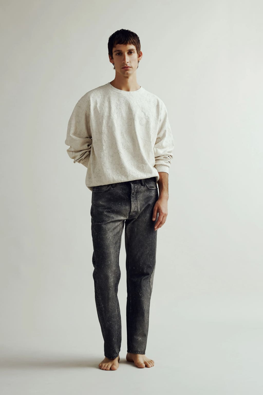 Modello con felpa e jeans trattati a mano con pasta effetto gesso – Cycle SS 25